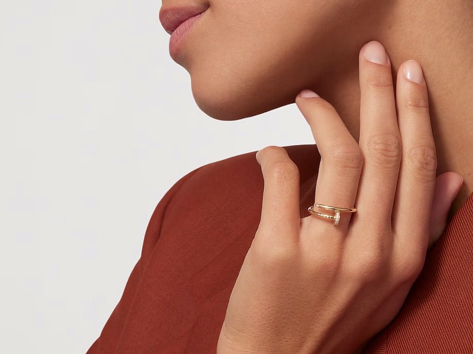 A stacking ring worn on the hand against a rust sleeve